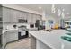 Bright kitchen featuring gray cabinetry, stainless steel appliances, a large island, and modern lighting at 2536 Shanti Dr, Kissimmee, FL 34746