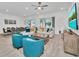 Bright living area featuring a large sofa, blue armchairs, modern decor, and a seamless flow to the dining area at 2536 Shanti Dr, Kissimmee, FL 34746