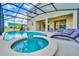 Outdoor pool and spa area with lounge chairs, a screened enclosure, and a view of the backyard at 2536 Shanti Dr, Kissimmee, FL 34746