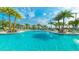 Large swimming pool with clear blue water, surrounded by palm trees and comfortable lounge chairs at 2536 Shanti Dr, Kissimmee, FL 34746