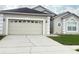 Close-up of the property's two-car garage, showing the driveway and adjacent landscaping details at 2577 Aster Cove Ln, Kissimmee, FL 34758