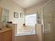 Bright main bathroom highlighting the garden tub, separate shower, and tiled flooring at 2577 Aster Cove Ln, Kissimmee, FL 34758