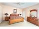 Well-lit main bedroom featuring a ceiling fan, neutral carpet, and classic wood furniture set at 2577 Aster Cove Ln, Kissimmee, FL 34758