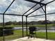 Outdoor grill on a patio in a screened-in lanai overlooking a scenic lake at 2577 Aster Cove Ln, Kissimmee, FL 34758