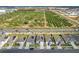 An aerial view showing houses with solar panels, a road with traffic, and a large green field at 281 Piave St, Haines City, FL 33844