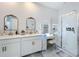 Bright bathroom featuring double sinks, vanity, lighted makeup mirror and a glass shower, offering a clean and luxurious space at 281 Piave St, Haines City, FL 33844