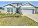 Charming home featuring a well-manicured front yard, a two-car garage and a stylish blue front door at 281 Piave St, Haines City, FL 33844