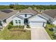 Charming home featuring a well-manicured front yard, a two-car garage and a stylish blue front door at 281 Piave St, Haines City, FL 33844