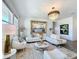 Elegant living room featuring a white sectional sofa, chic chandelier, and a large framed mirror at 281 Piave St, Haines City, FL 33844