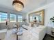 Bright living room featuring a modern chandelier, large mirror, and comfortable seating near the windows at 281 Piave St, Haines City, FL 33844