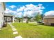 Backyard features a manicured lawn with stepping stones and a screened-in lanai at 31792 Broadwater Ave, Leesburg, FL 34748