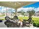 View of the screened-in patio with wicker furniture overlooking a manicured front lawn with beautiful landscaping at 31792 Broadwater Ave, Leesburg, FL 34748