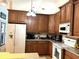 The kitchen is well-lit, with wooden cabinets, a white refrigerator, and modern appliances on the counter at 3285 Majestic Oak Dr, St Cloud, FL 34771