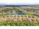 Scenic aerial view of a suburban neighborhood featuring homes with tile roofs and a serene pond at 3723 Isles Arbor Ln, Kissimmee, FL 34746