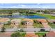 Aerial view of a lovely neighborhood surrounding a large pond with water feature and lush landscaping at 3723 Isles Arbor Ln, Kissimmee, FL 34746