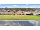 Back view of the home with a tile roof, surrounded by a lush lawn and picturesque lakefront scenery at 3723 Isles Arbor Ln, Kissimmee, FL 34746