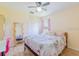 Cozy bedroom featuring a ceiling fan, light wood floors, and a full-length mirror at 4119 Maidu Ct, St Cloud, FL 34772