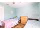 This sunny bedroom features two beds, a light blue wall design and wood floors, providing a serene space at 4119 Maidu Ct, St Cloud, FL 34772