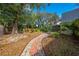 Landscaped backyard with a brick and stone walkway and mature trees at 4318 Oak Ct, St Cloud, FL 34769