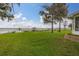 Green lawn with mature trees framing a scenic view of the lake and docks, adding to the charm of this waterfront property at 4815 Cypress Dr, Lake Wales, FL 33898