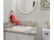 This powder room includes a granite countertop with a decorative mirror and a toilet at 4815 Cypress Dr, Lake Wales, FL 33898