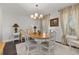 Bright dining area with wood table, stylish chairs, decorative chandelier, and natural light from the large windows at 4815 Cypress Dr, Lake Wales, FL 33898