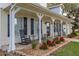 Charming front porch with rocking chairs, brick accents, and decorative landscaping at 4815 Cypress Dr, Lake Wales, FL 33898