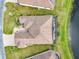 A bird's-eye view highlights a home with landscaping adjacent to a peaceful pond at 484 Villa Park Rd, Kissimmee, FL 34759