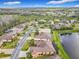 Birds eye view of a community with tree lined streets, a lake, and pristine landscaping at 484 Villa Park Rd, Kissimmee, FL 34759