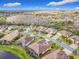 Aerial view of a residential neighborhood with well-maintained houses, green lawns, and mature trees at 484 Villa Park Rd, Kissimmee, FL 34759