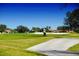 Scenic golf course view with golfer, lush green fairway, sand trap, and well-maintained landscaping at 484 Villa Park Rd, Kissimmee, FL 34759