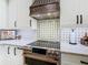 Close-up of gourmet kitchen featuring a range with decorative copper accents and stylish backsplash at 484 Villa Park Rd, Kissimmee, FL 34759