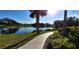 Picturesque view of a community pond, golf course, and landscaped pathway with lush foliage at 484 Villa Park Rd, Kissimmee, FL 34759