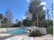 Community pool and lounge area surrounded by palm trees on a sunny day at 492 Prestwick Pl # 2, Kissimmee, FL 34759