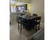 Open dining area features a dark wood table with seating for four and kitchen view at 492 Prestwick Pl # 2, Kissimmee, FL 34759