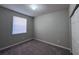 This bedroom features a large window, neutral walls and carpet, and a closet at 501 Terrace Ridge Cir # 501, Davenport, FL 33896