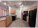 Kitchen featuring wood cabinets, black appliances, laminate countertops and grey flooring at 501 Terrace Ridge Cir # 501, Davenport, FL 33896