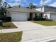 Well-manicured lawn enhances this single-Gathering home's curb appeal, featuring a long driveway and coordinated shutters at 5295 Timberland Ave, St Cloud, FL 34771