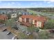 Aerial view of condo buildings showcasing red tiled roofs, exterior balconies, the highway, and the surrounding landscape at 5560 Metrowest Blvd # 304, Orlando, FL 32811