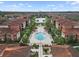 Aerial view of community pools, lounge chairs, cabanas, surrounding landscaping and pond at 5560 Metrowest Blvd # 304, Orlando, FL 32811