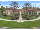 The community clubhouse featuring meticulous landscaping with palms and a walkway to the entrance at 5560 Metrowest Blvd # 304, Orlando, FL 32811