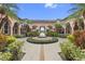 Courtyard with fountain, arches and stucco columns featuring well-maintained lush landscaping at 5560 Metrowest Blvd # 304, Orlando, FL 32811