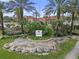 Attractive landscaping and towering palm trees surround the Palms Club community sign at 5560 Metrowest Blvd # 304, Orlando, FL 32811