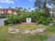 Community entrance sign surrounded by lush landscaping including palms, rocks and manicured shrubs at 5560 Metrowest Blvd # 304, Orlando, FL 32811