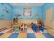 Colorful playroom featuring whimsical wall murals, tables, and chairs for creative activities at 5560 Metrowest Blvd # 304, Orlando, FL 32811