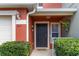 Close up of front door featuring a black door, potted plants, manicured landscaping, and a cozy front entrance at 565 Cresting Oak Cir # 87, Orlando, FL 32824