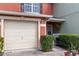 Close up of the front entrance and one car garage featuring manicured landscaping, and a cozy front entrance at 565 Cresting Oak Cir # 87, Orlando, FL 32824