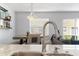 Close up of modern kitchen with stainless steel faucet, marble countertops, and view to dining area at 565 Cresting Oak Cir # 87, Orlando, FL 32824