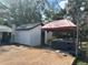 Backyard with a wooden deck featuring a covered hot tub and a white storage shed at 610 Illinois Ave, St Cloud, FL 34769