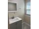 Bathroom with gray vanity, gray tile floor, and natural light from window at 610 Illinois Ave, St Cloud, FL 34769